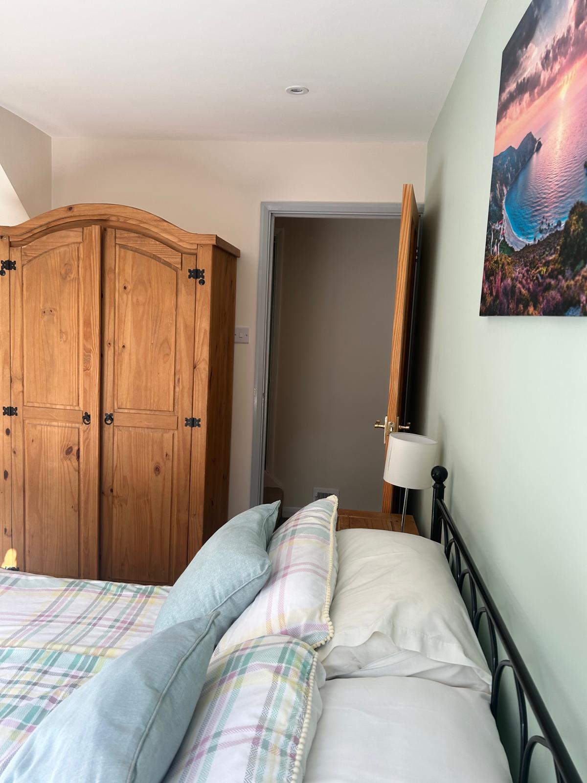 Refurbished bedroom with pine wardrobe and newly decorated walls