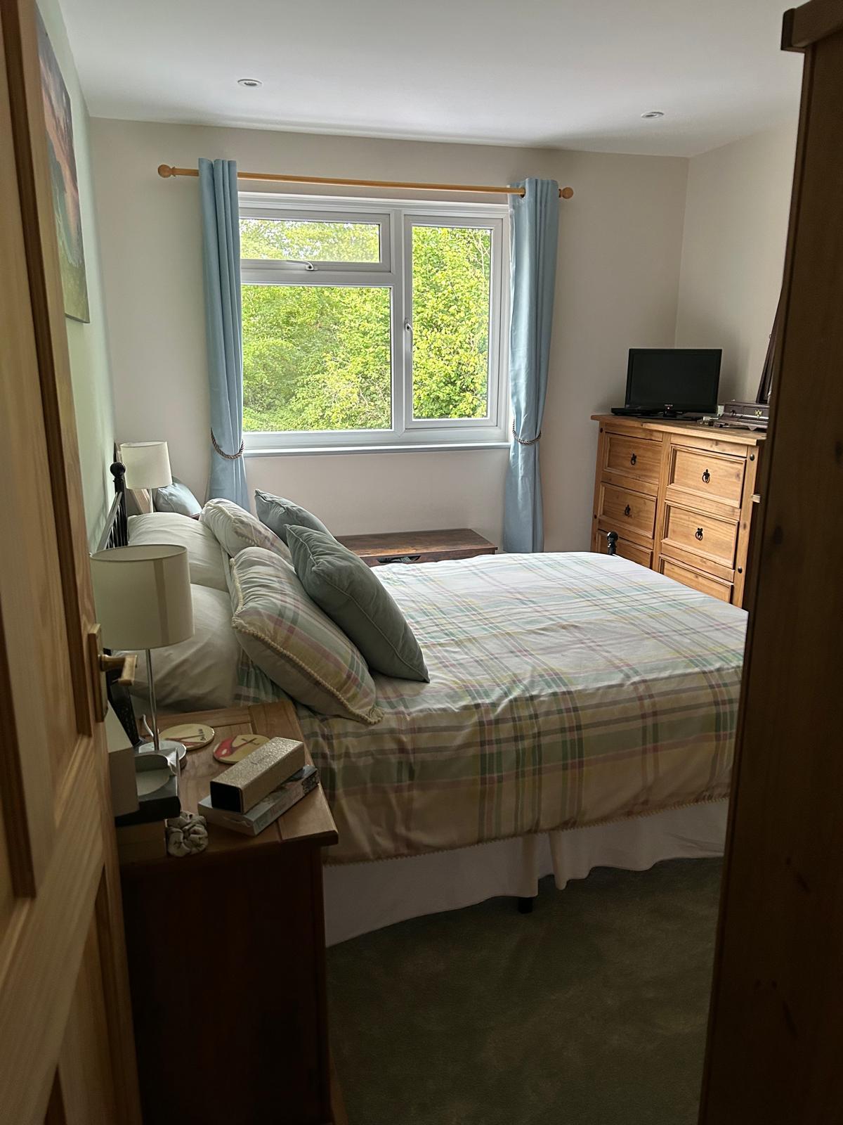 Refurbished bedroom viewed from the doorway with new flooring and decoration