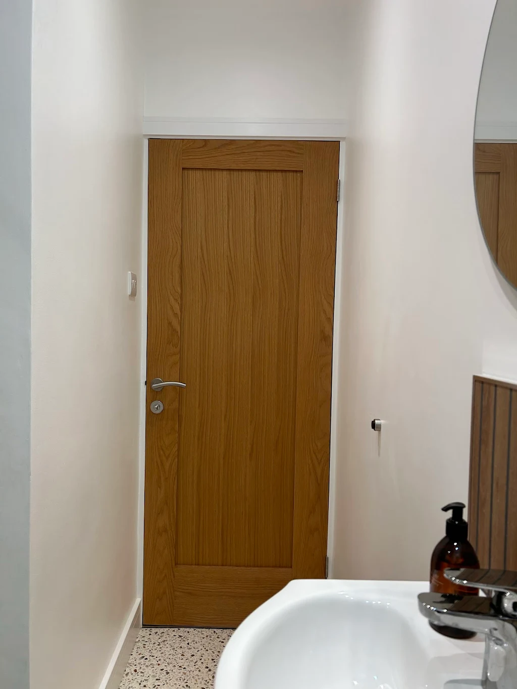 Modern wooden interior door in white hallway