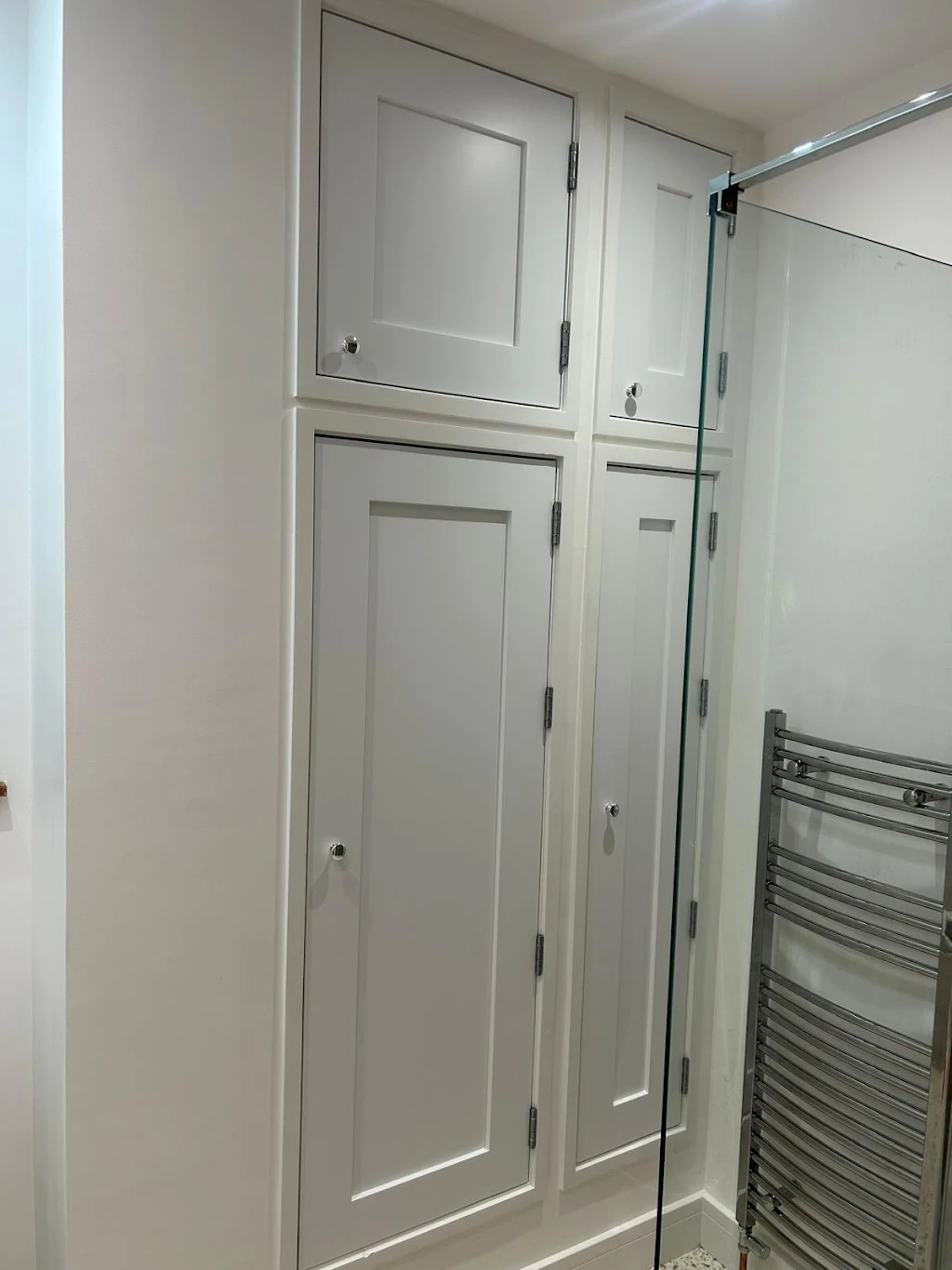 Modern bathroom with white cabinetry and glass shower enclosure