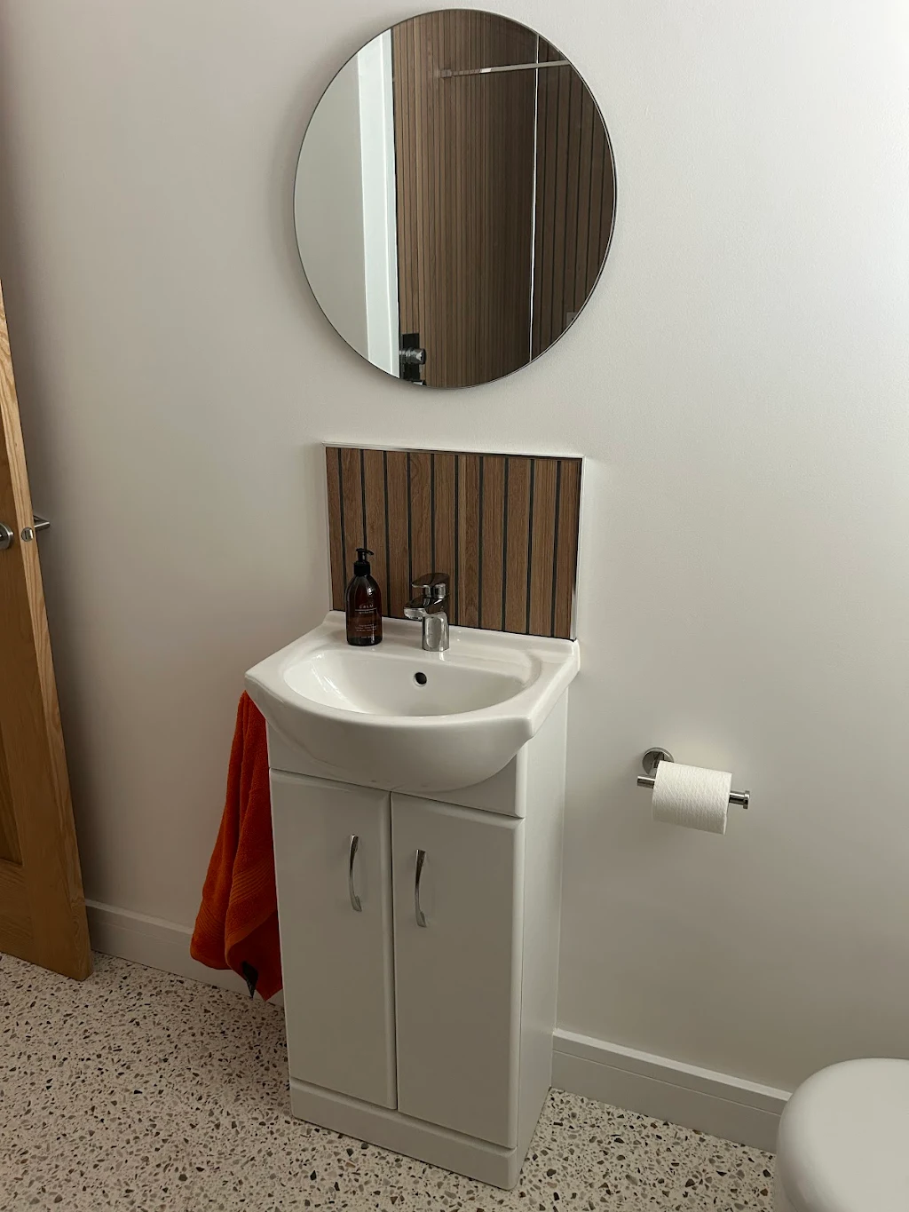 Modern bathroom with white sink vanity and round mirror