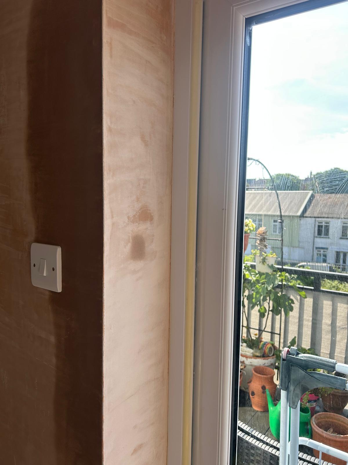 Freshly plastered reveal around the new door frame