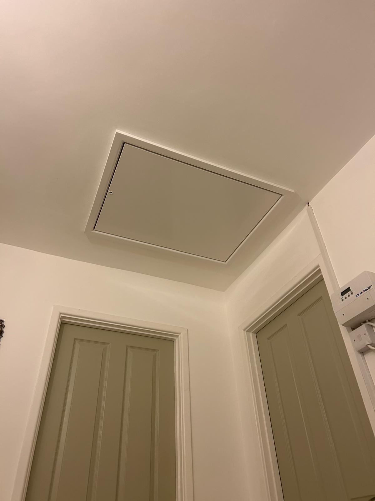 Finished loft access hatch blended into the hallway ceiling