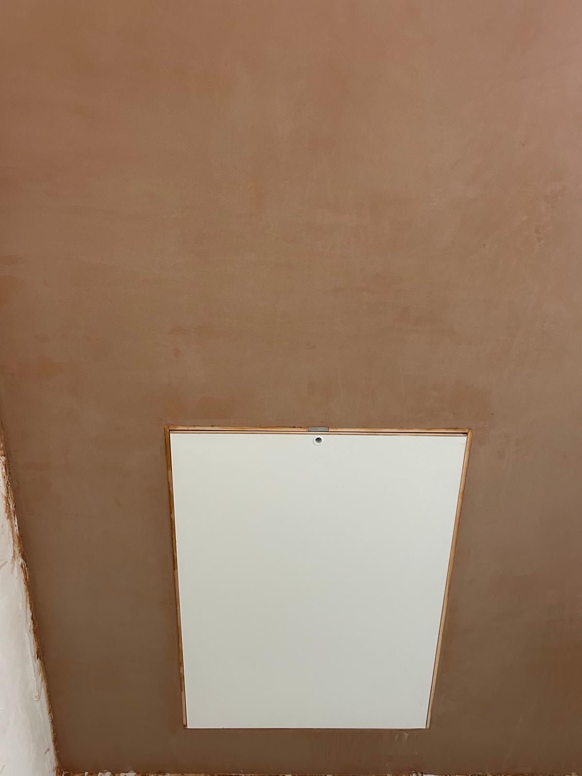 New loft access hatch fitted into a freshly plastered ceiling