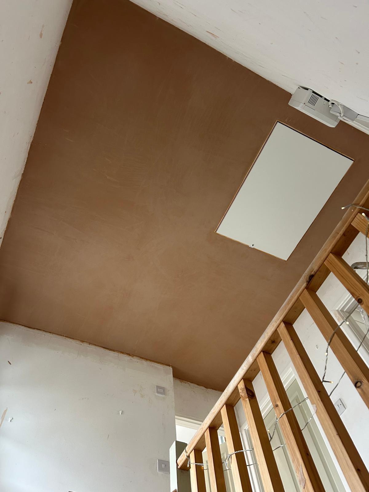 Loft hatch installation viewed from the staircase with fresh plastering