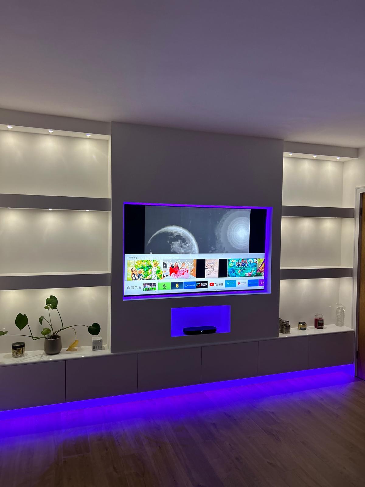 Wall-mounted TV in a bespoke media wall with illuminated display shelves