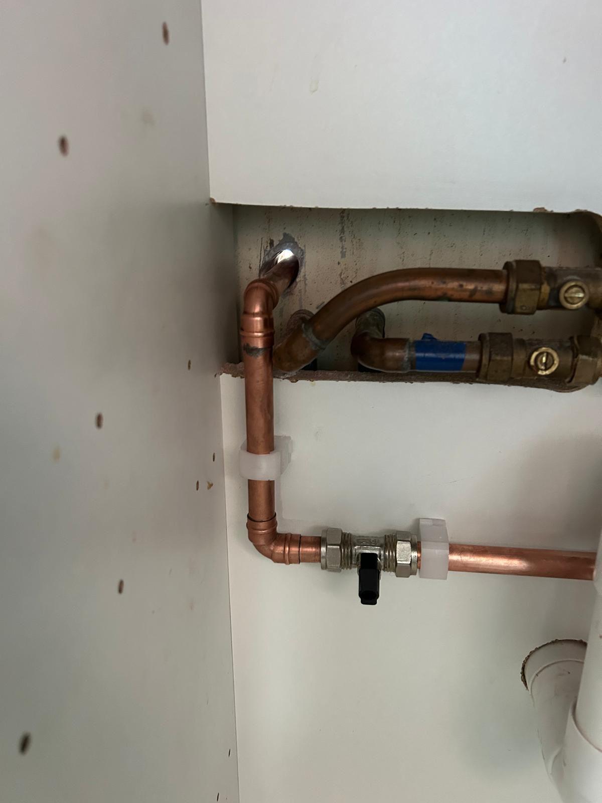 Neatly routed internal copper pipework with isolation valves feeding the outside tap